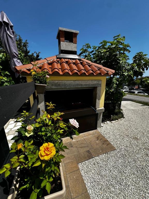 a outdoor fireplace with flowers in a garden at Lulic in Labin
