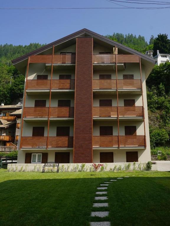 an apartment building with a lawn in front of it at Casa vacanze moderna a 500m dalle piste in Aprica