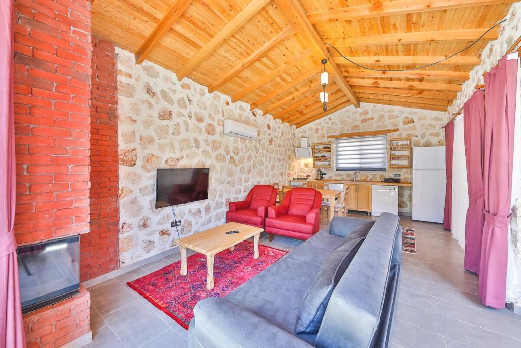 a living room with red furniture and a brick wall at Spacious 2BR Stone Villa with Pool & BBQ in Kalkan