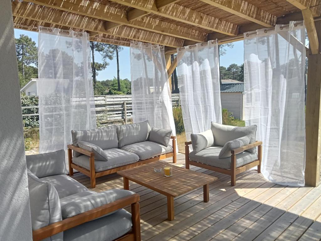 - une véranda avec des canapés et une table basse dans l'établissement Santa Monta, à Montalivet-les-Bains