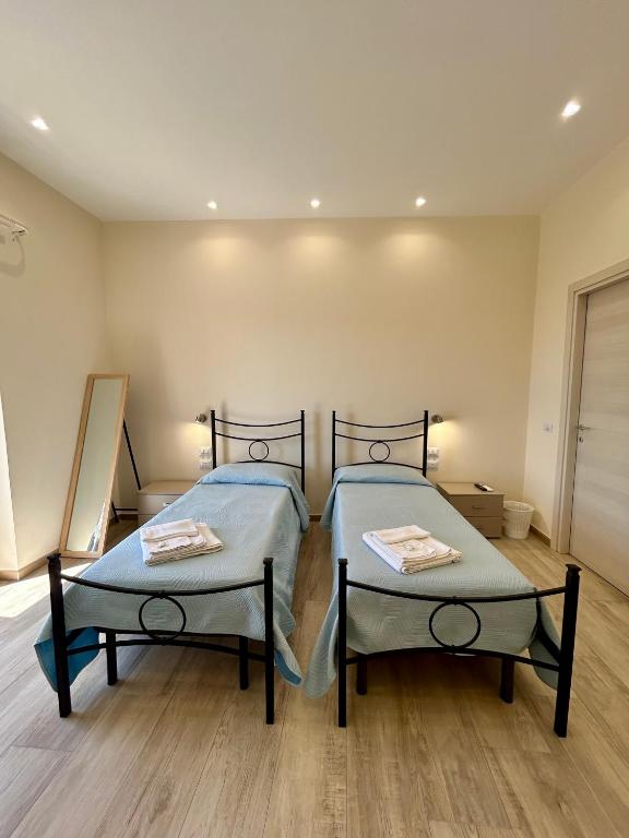 two beds in a room with wooden floors at B&b Al Centro Nicosia in Nicosia