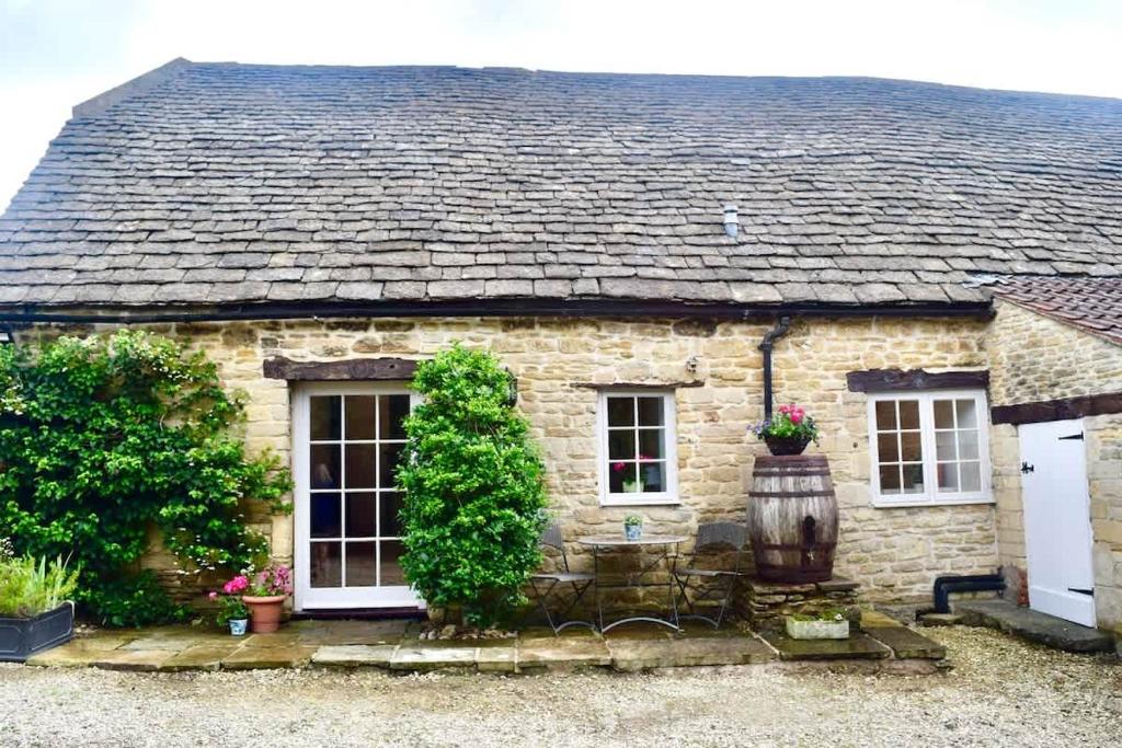 a stone house with a shingled roof at Stunning stone cottage on Bath's doorstep in Box