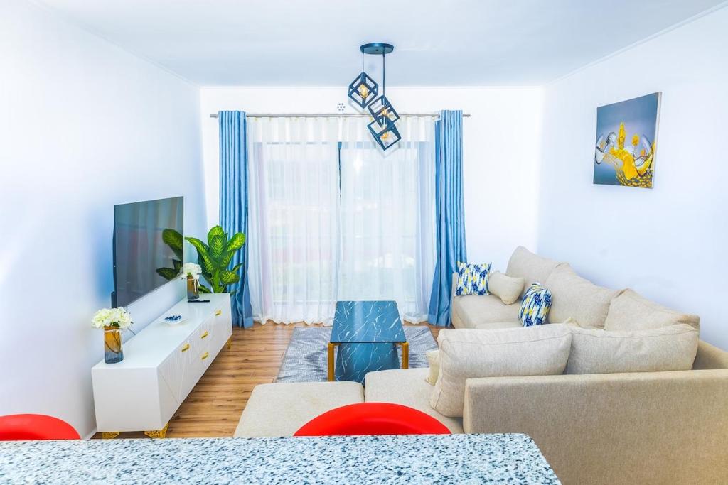 a living room with a couch and a tv at Unity Haven Tatu City in Tatu City