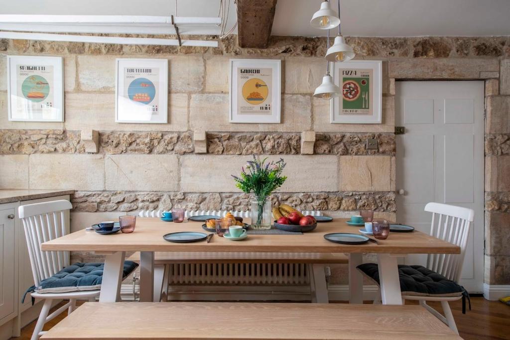 a dining room with a wooden table and chairs at Exquisite Historic Hideaway in Bradford on Avon