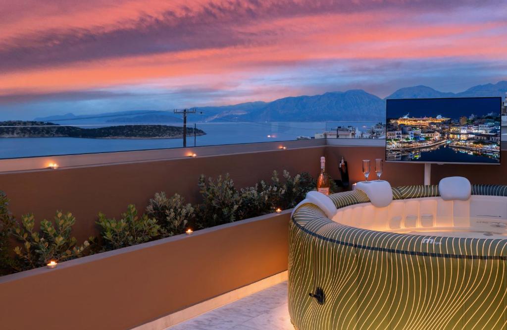 un balcón con vistas al océano al atardecer en Evilion Home 2, en Agios Nikolaos