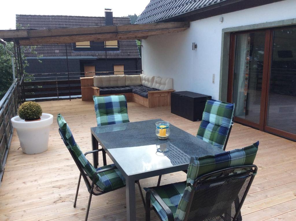 a patio with a table and chairs on a deck at Ferienhaus Dell in Möhnesee