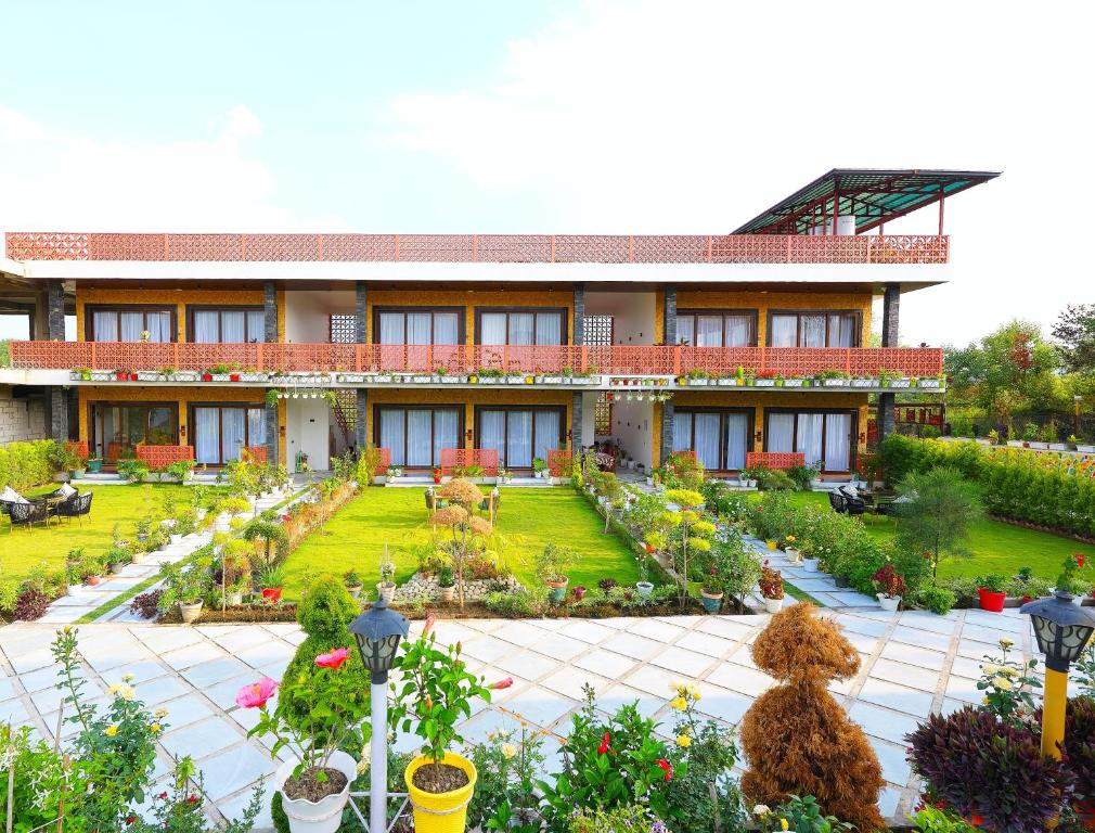 a teddy bear in front of a building with a garden at Chitralekha Boutique Resort in Rājpur