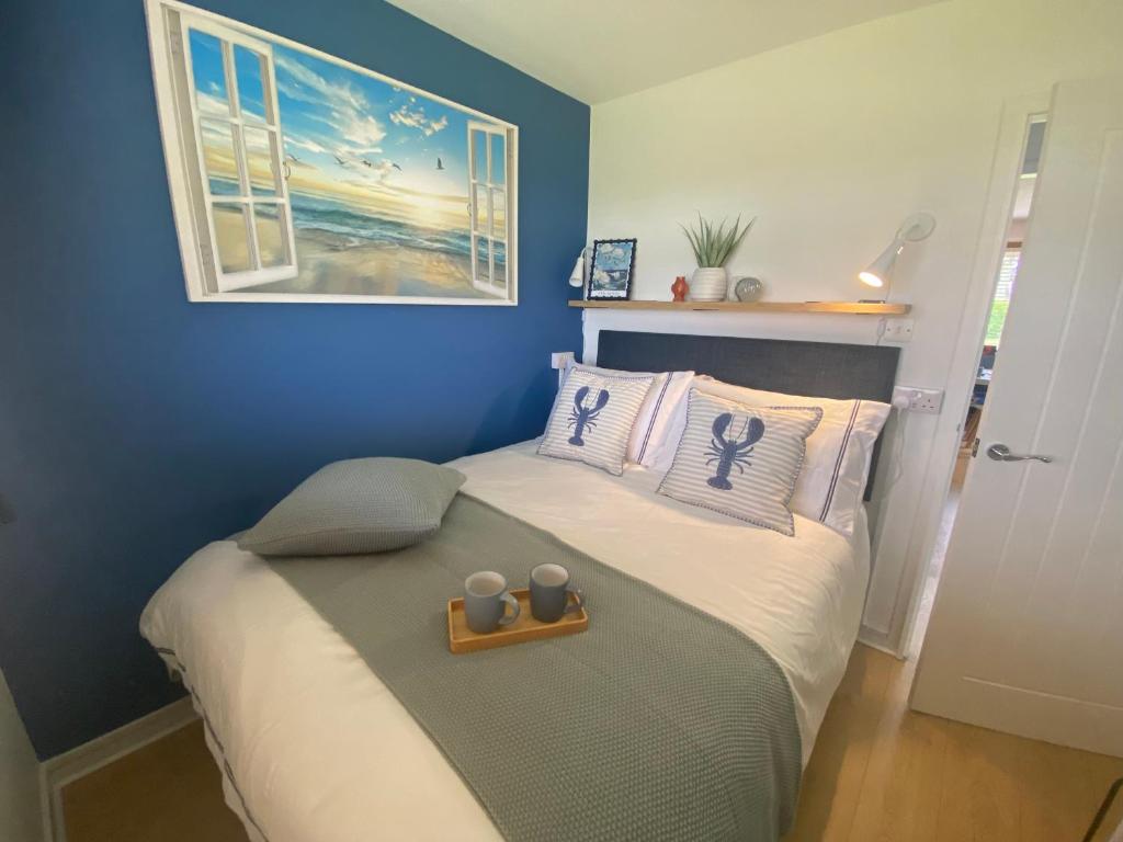 a blue bedroom with a bed with two candles on it at Seagulls Rest in Isle of Wight