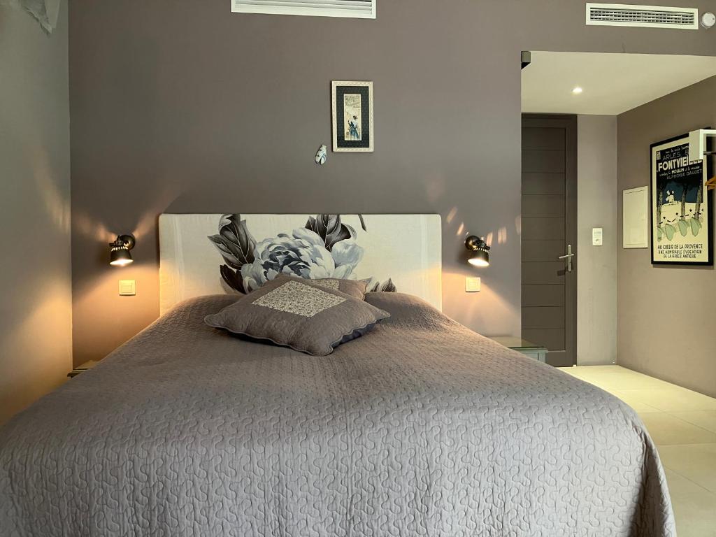 a bedroom with a large bed and two lights at L' Oustau Blanc in Fontvieille