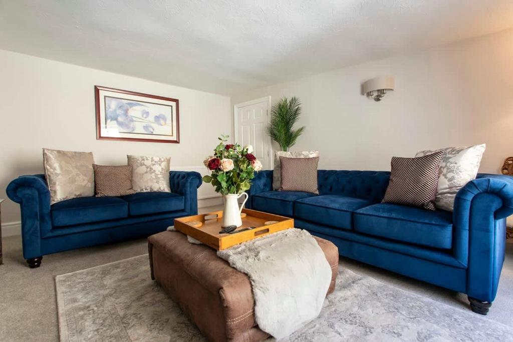 a living room with two blue couches and a table at Central, beautiful home - with parking in Bradford on Avon