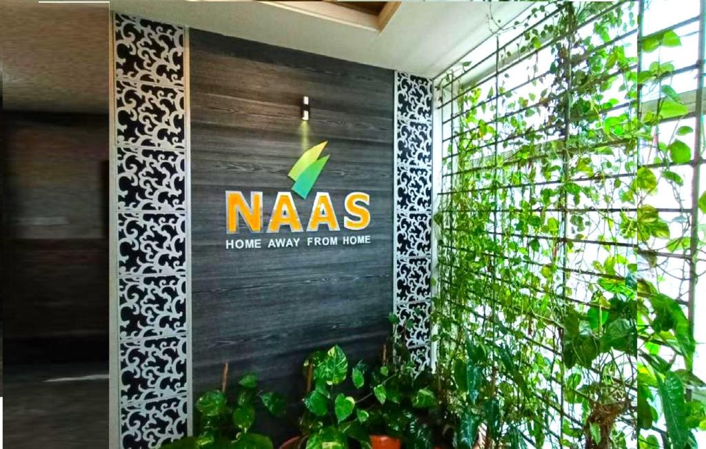 a nass sign on a wall next to some plants at NAAS Serviced Apartments in Dhaka