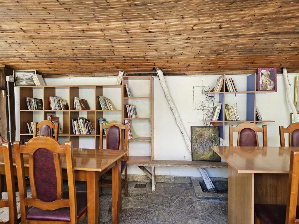 a room with a table and chairs and shelves with books at Traveler Hostel 2 in Shkodër