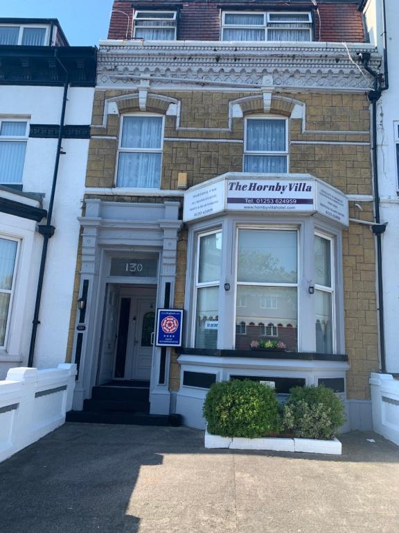 a store front of a brick building with a window at Hornby Villa B&B Couples & Families Only- Quiet Central Location- Near To Winter Gardens in Blackpool