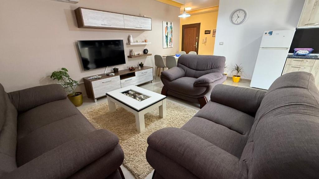 a living room with two couches and a tv at Your Home in Pogradec