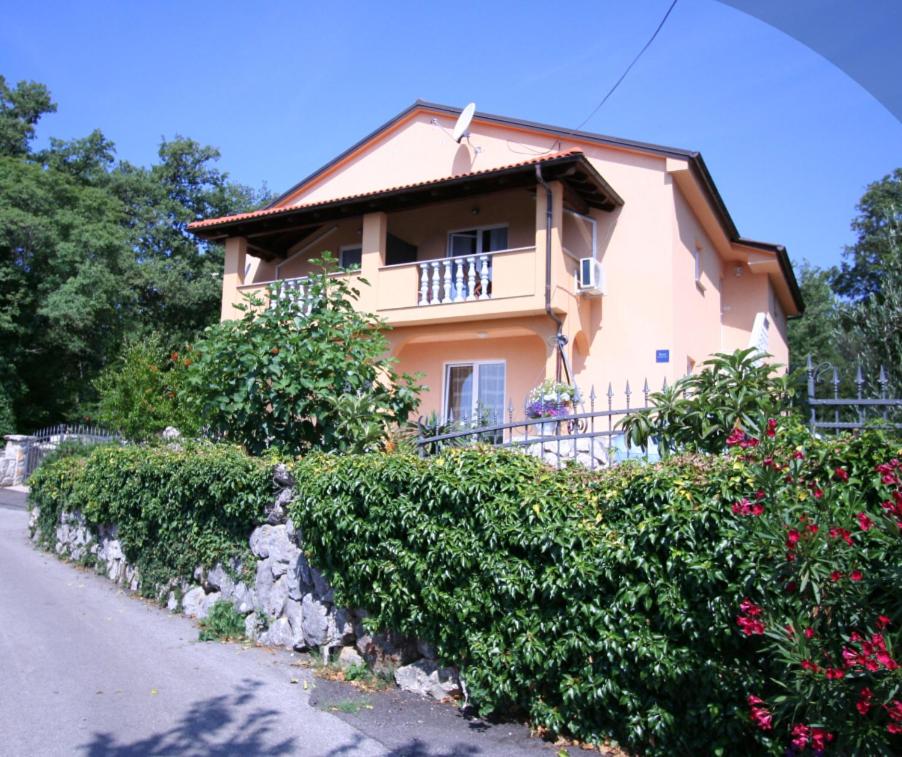 a house with bushes in front of a building at Apartman Andrija Polje in Polje