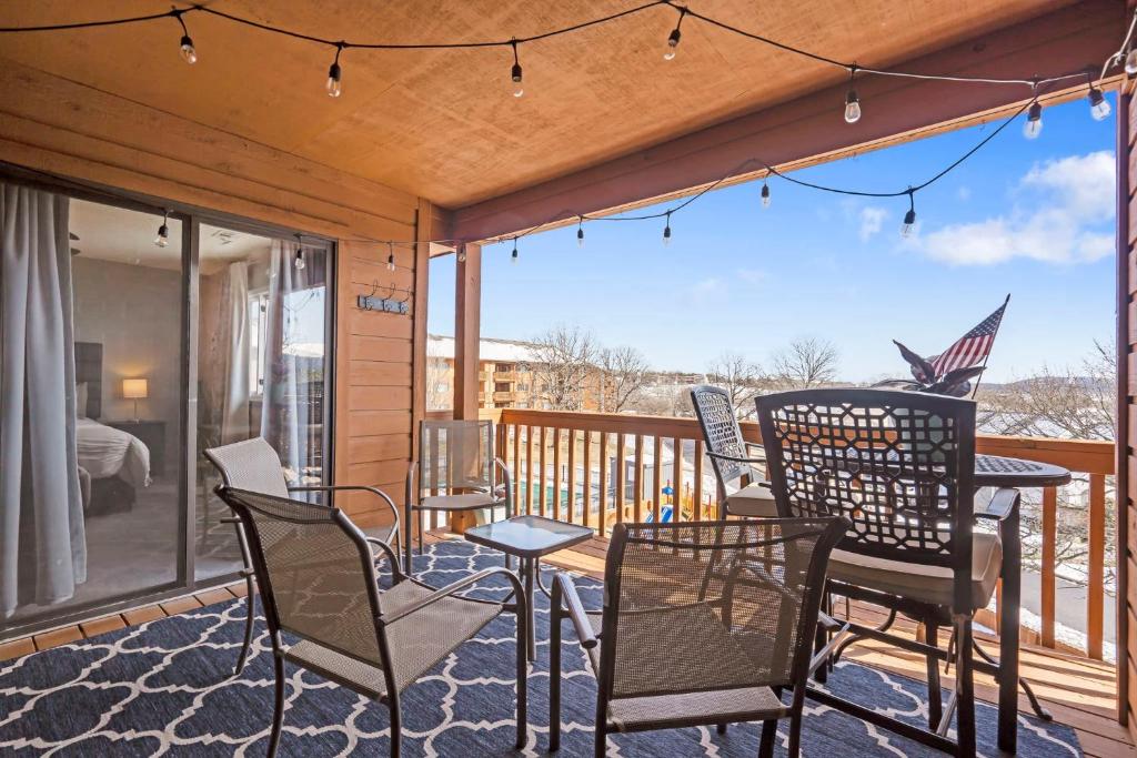 ブランソンにあるPoolside Oasis at the Pointe - 2BR Condo Minutes From Table Rock Lakeのパティオ(椅子、デッキ上のテーブル付)