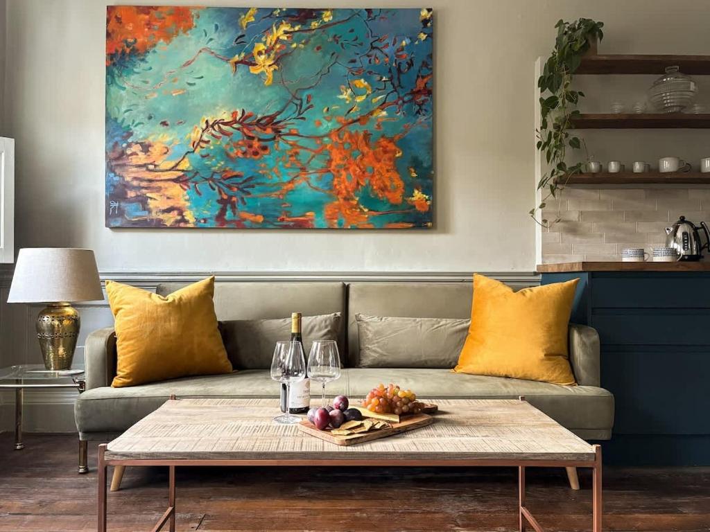a living room with a couch and a painting at Bijou Beauty - Bath Abbey in Bath