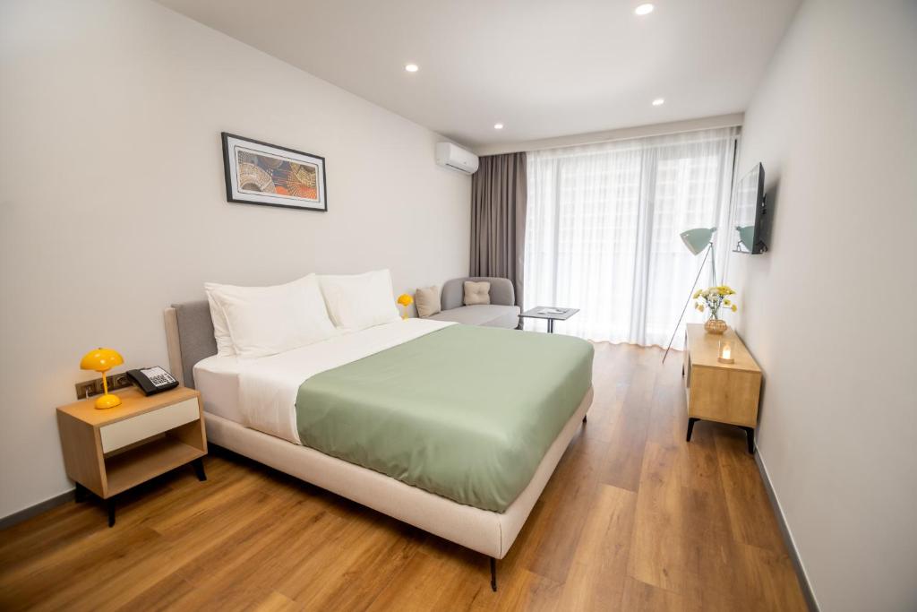 una habitación de hotel con una cama y una silla en Blue Sky Apart-Hotel Batumi, en Batumi