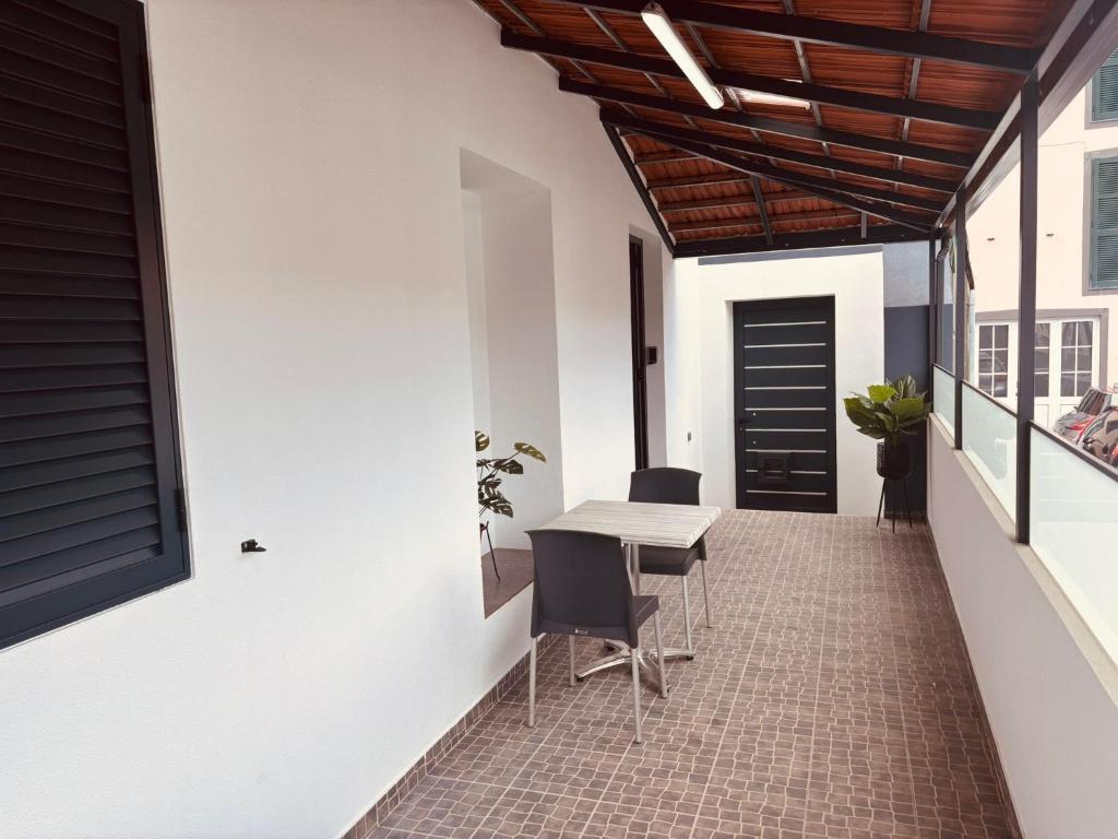 a room with a table and chairs on a patio at Vila Ramos I in Funchal