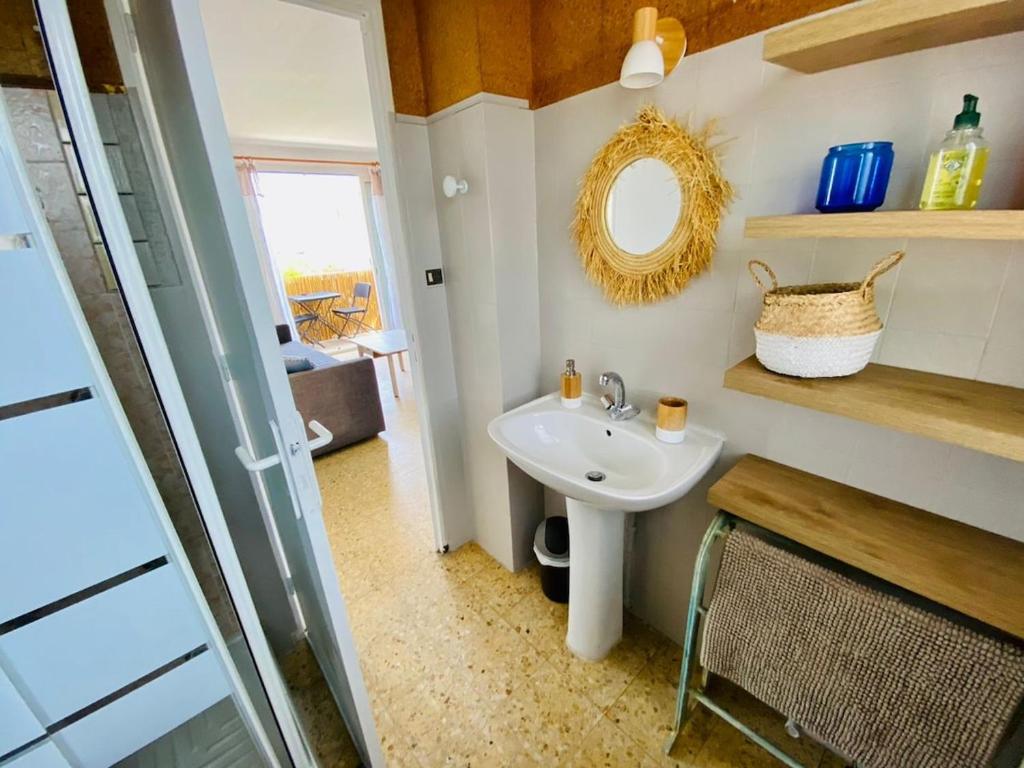 a bathroom with a sink and a mirror at T3 vue mer 100m jardin in Hyères