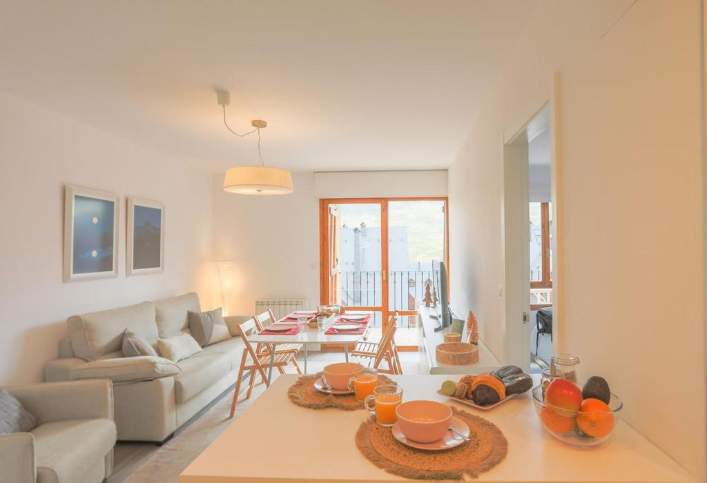 ein Wohnzimmer mit Sofa und Tisch in der Unterkunft Collado, terraza con vistas y garaje - Arafita Apartamentos in Formigal