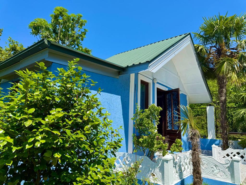 a blue house with a green roof at Коттедж в саду роз in Chakvi