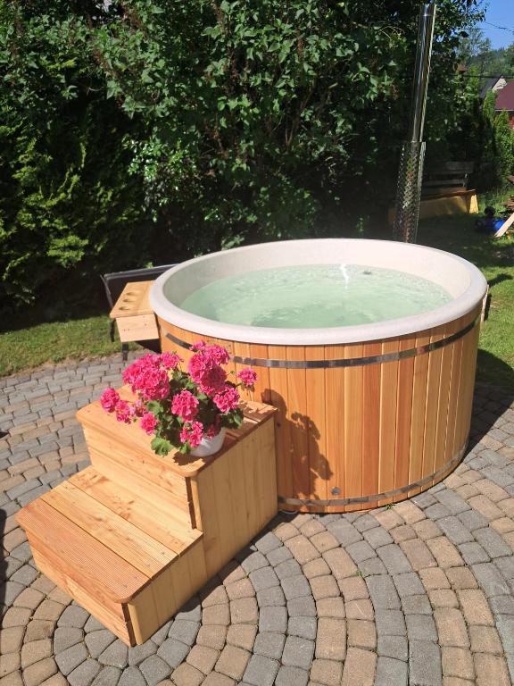a large hot tub with flowers in a wooden crate at Kwatery Maciata in Biały Dunajec