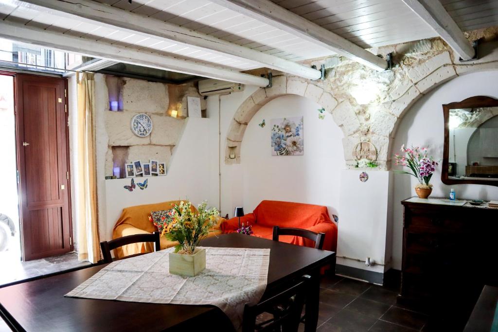 a dining room with a table and a red chair at Casetta giuly in Ragusa