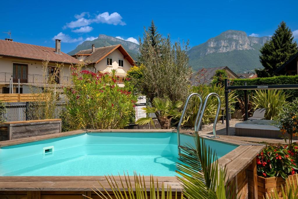 une piscine dans un jardin avec des montagnes en arrière-plan dans l'établissement La suite des Sommets, à Barberaz