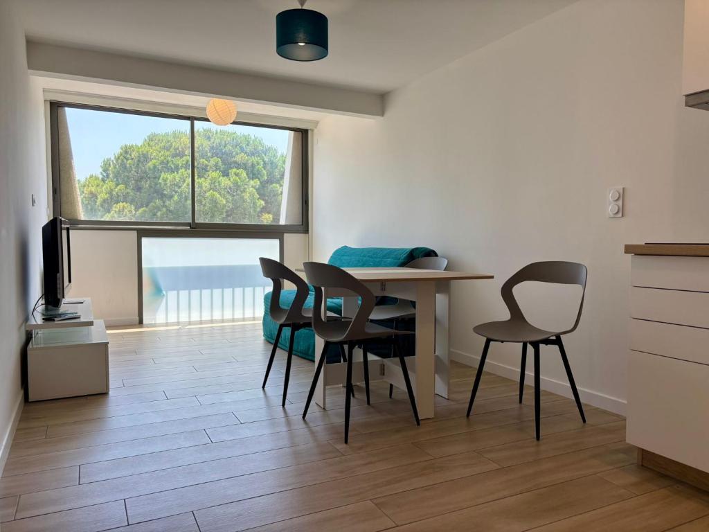 eine Küche und ein Esszimmer mit Tisch und Stühlen in der Unterkunft Appartement les pieds dans l'eau Saint Cyprien in Saint-Cyprien