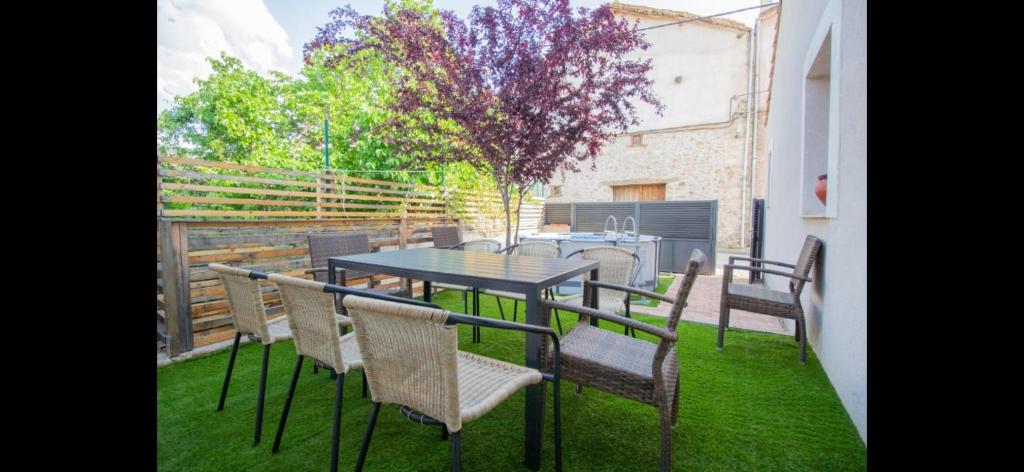 patio con tavolo e sedie sull'erba di La Casa del Maestro a Cerezo de Abajo