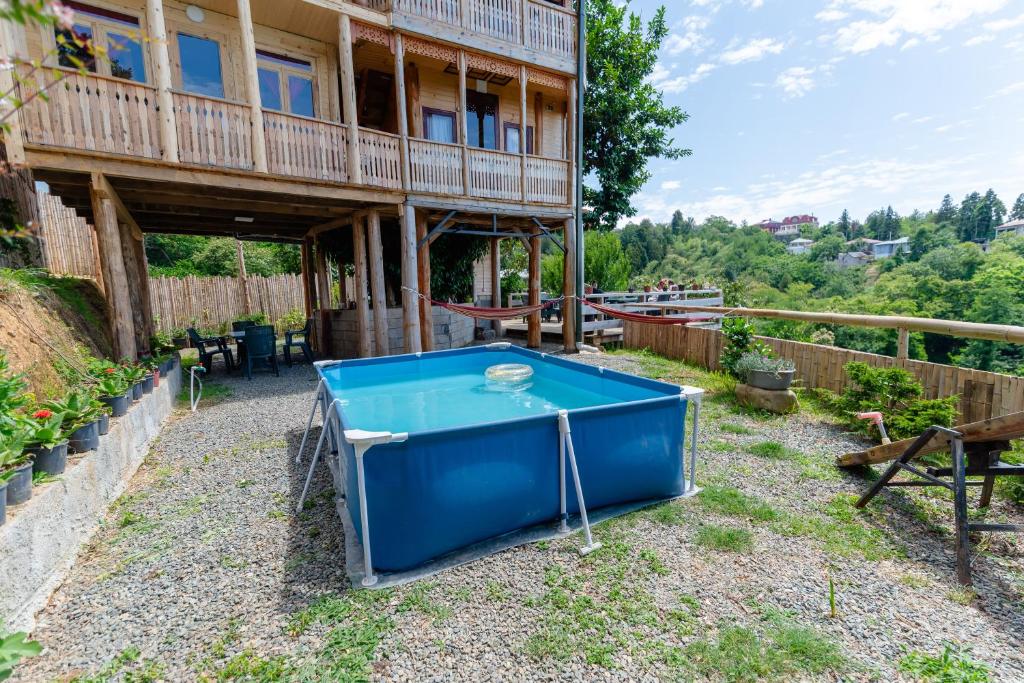 a blue ping pong table in front of a house at Private Treehouse for 10 Guests with Sea View & Plunge Pool in Ts'ikhisdziri