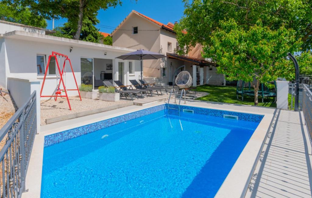 a swimming pool in front of a house at Holiday Home Kristina - Makarska by Villas Guide in Donji Vinjani