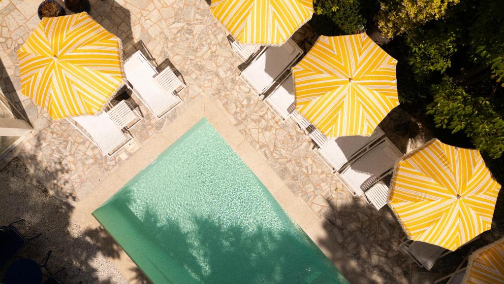 an overhead view of a swimming pool with umbrellas at Hôtel Le Sud in Juan-les-Pins