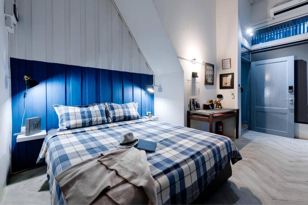 een blauwe en witte slaapkamer met een bed en een wastafel bij Non Inn The Barber King and Twin Rooms with Vintage Charm and Unique Design near Riverside and ICONSIAM in Bang Rak