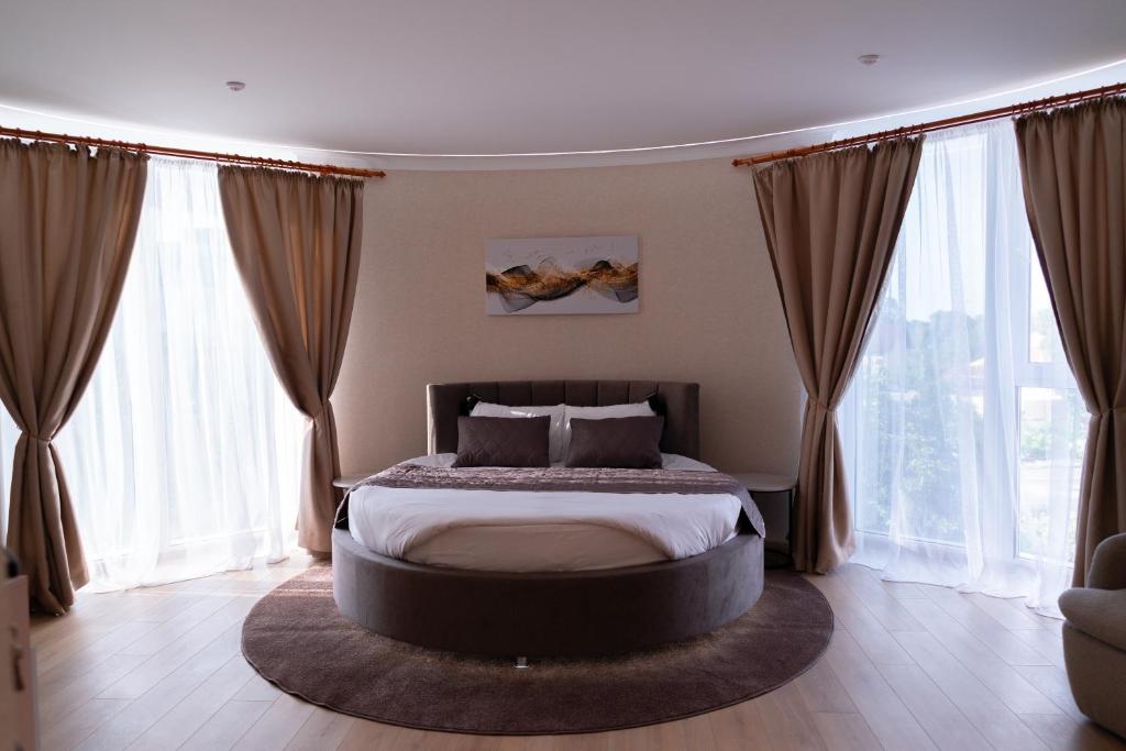 a bedroom with a large bed in front of windows at Hotel Palace Ukraine in Mykolaiv