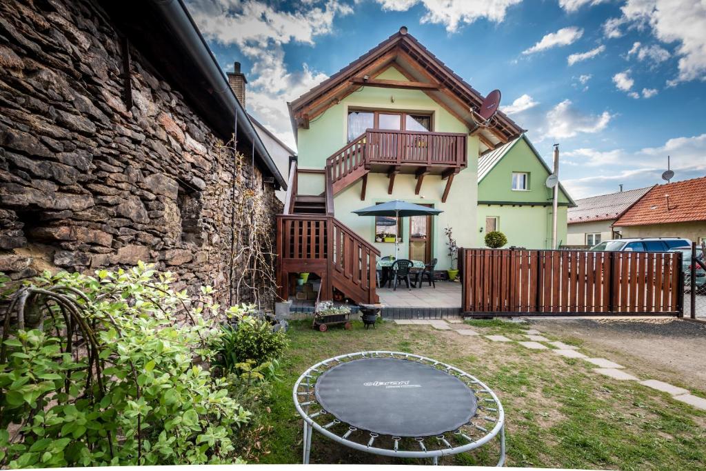 a house with a balcony and a table in the yard at Ubytovanie u Štefana in Závažná Poruba