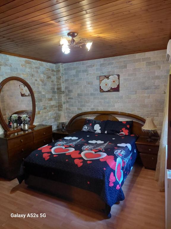 a bedroom with a bed and a mirror at The Love Holiday House in Tris Elies