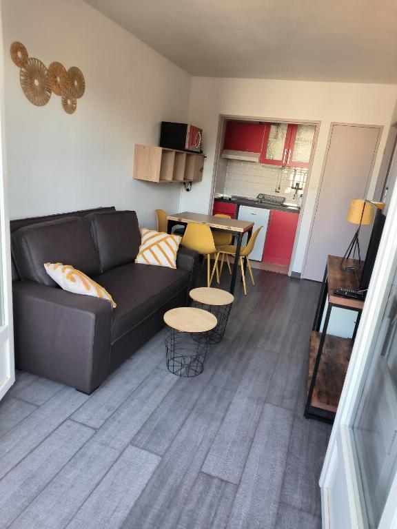 un salon avec un canapé et une table dans l'établissement L'Escale Bleue, à Argelès-sur-Mer