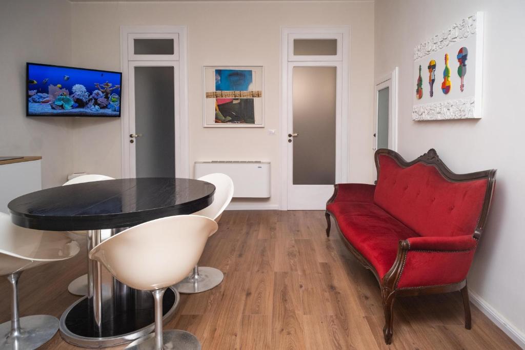 a living room with a red couch and a table at Esperia Maison B&b in Montesarchio