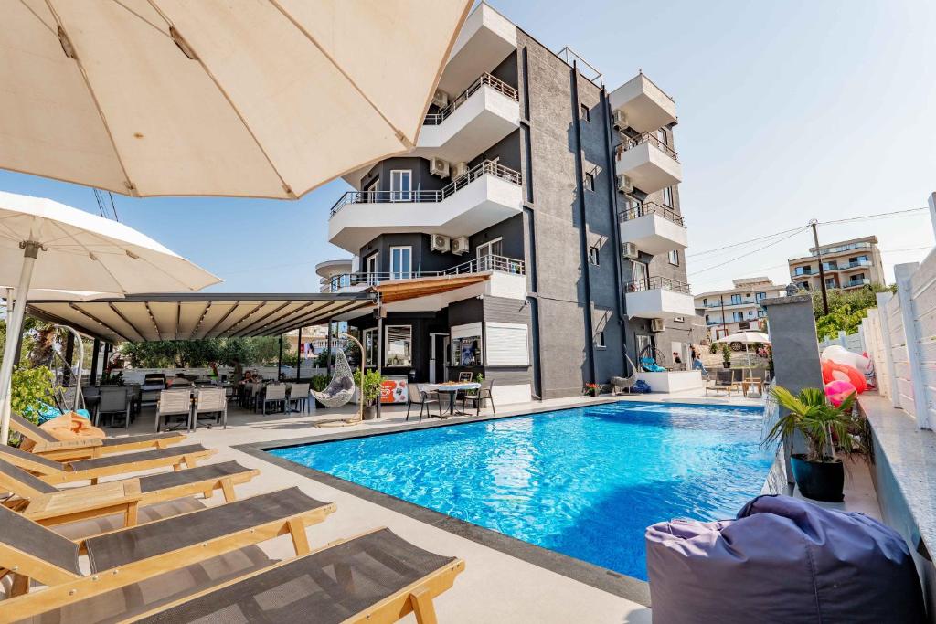una piscina frente a un edificio en Sunshine Hotel, en Ksamil
