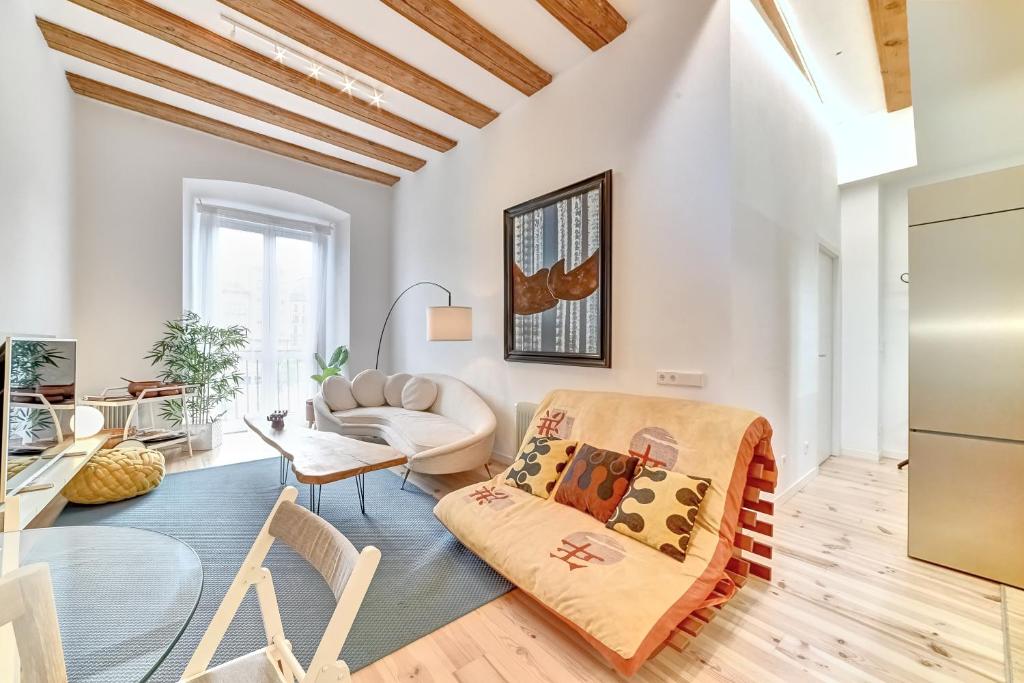 a living room with white walls and a wooden ceiling at Castillo 31 by Clabao in Pamplona