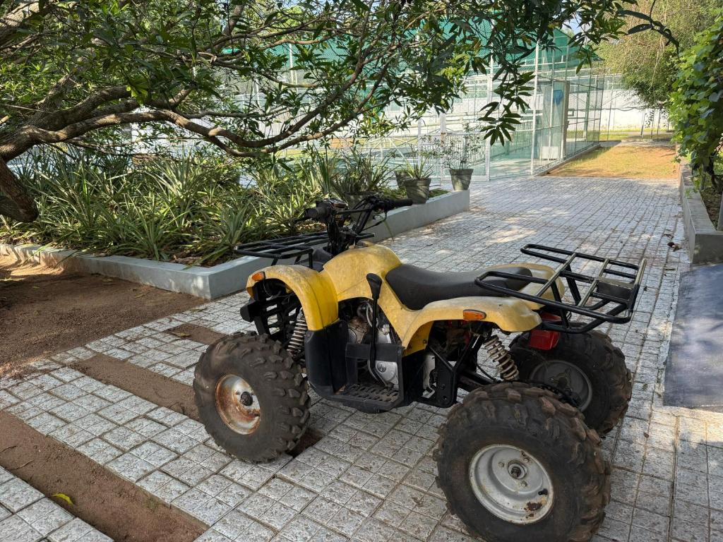 ein gelbes Quad, das auf einem Bürgersteig geparkt ist in der Unterkunft Farm House in Kollam
