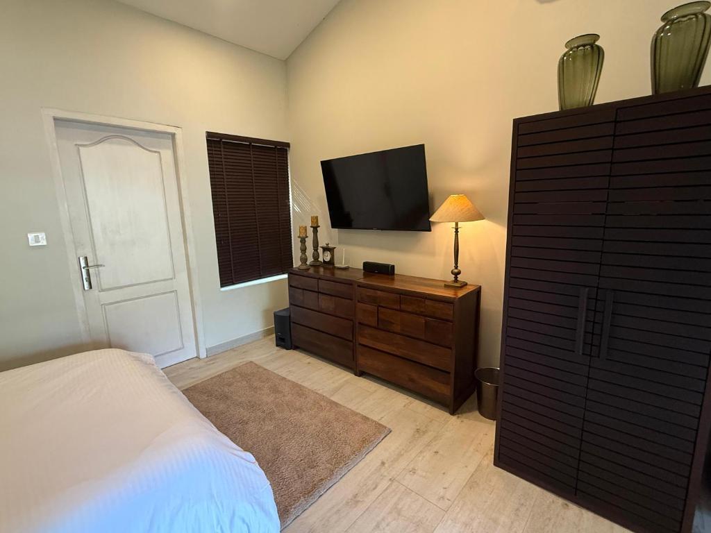 a bedroom with a bed and a flat screen tv at Farm House in Kollam