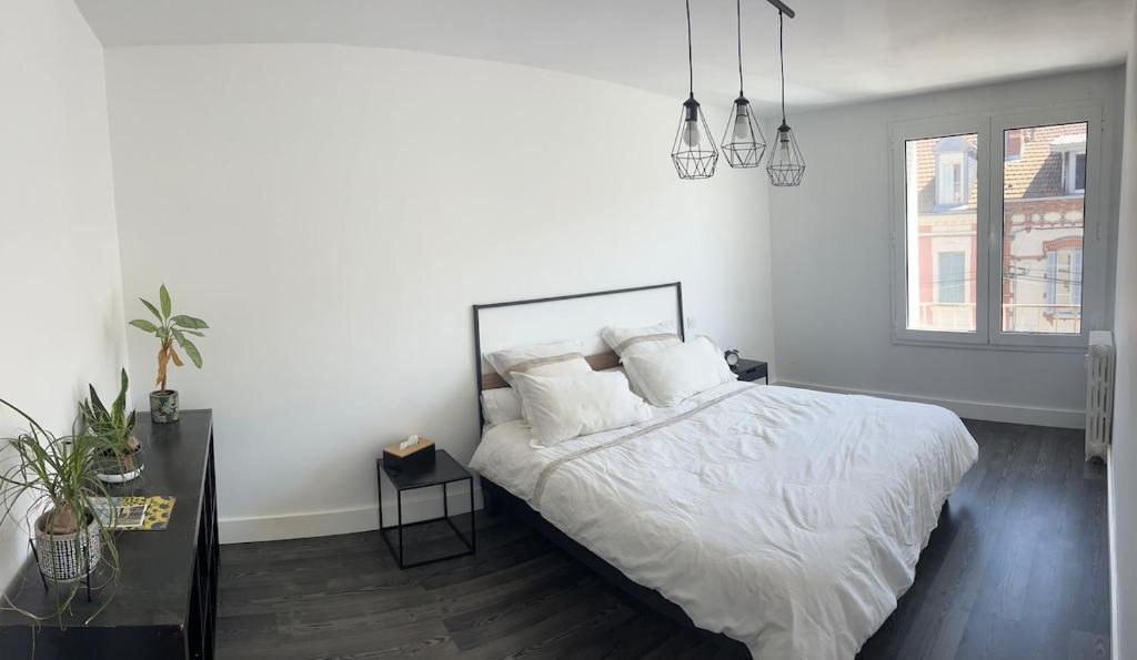 Un dormitorio blanco con una cama y una ventana. en Appartement la gare, en Tarbes