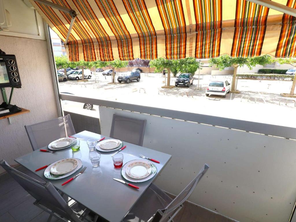 d'une table et de chaises avec vue sur le parking. dans l'établissement Studio climatisé proche mer avec terrasse, park privé et équipements modernes - FR-1-307-198, au Grau-du-Roi