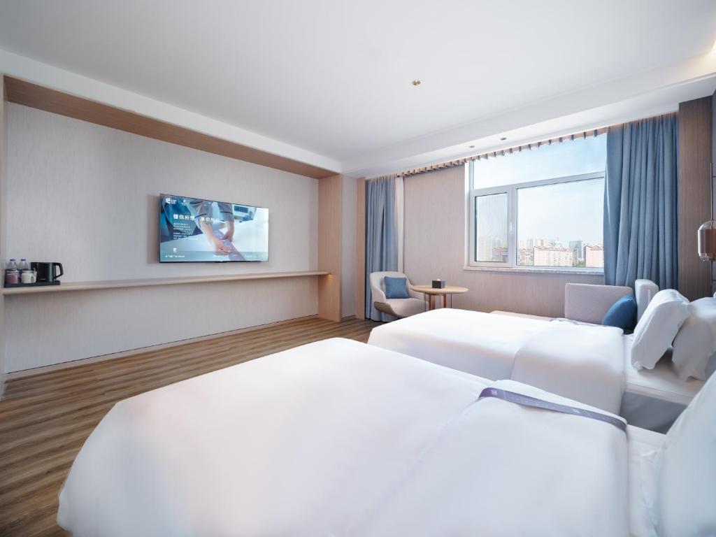Postel nebo postele na pokoji v ubytování Elong Hotel City Hall Branch