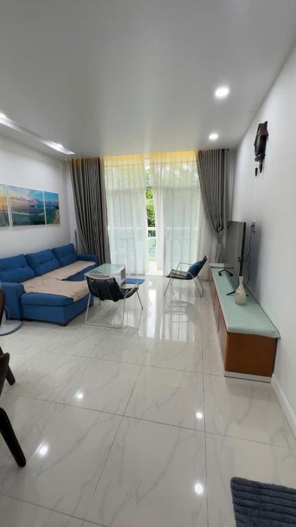 a living room with a blue couch and a table at Căn Hộ 2 PN Ocean-vista in Ấp Phú Tịnh (2)