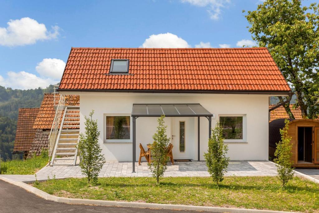 a small white house with an orange roof at Mirola homes - rent in nature in Zagorje ob Savi