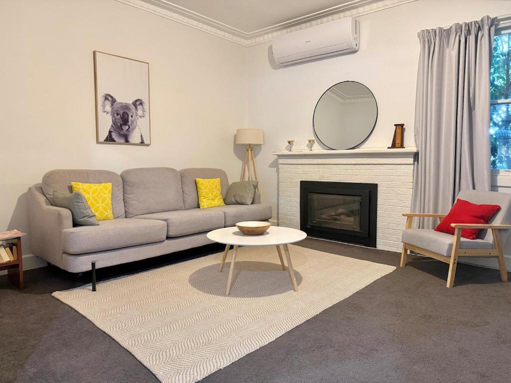 a living room with a couch and a fireplace at Bendigo Bliss - Cheerful & Spacious Home in Bendigo in Kangaroo Flat